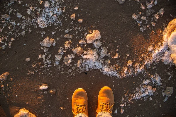 Mens winter beige laarzen op een achtergrond van ruw ijs en zand. Bovenaanzicht — Stockfoto