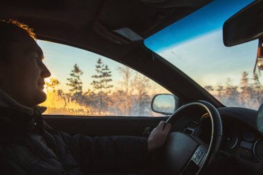 Kış ormanlarında arabayla gezen yakışıklı genç adam. Kış harikalar diyarı