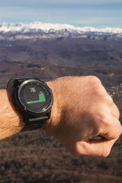 Man checks height in mountains with smartwatch