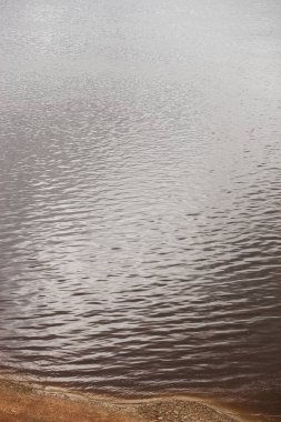 Gümüş su yüzeyi ve yukarıdan kıyı manzarası