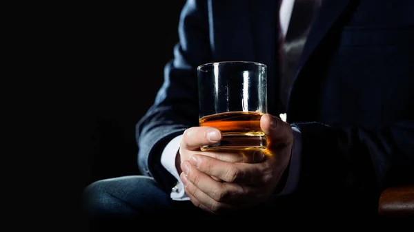 Zbliżenie poważnego biznesmena trzymającego whisky ilustruje koncepcję przywileju wykonawczego. — Zdjęcie stockowe