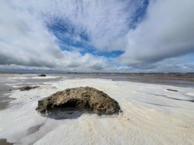 Kumsaldaki fırtına sırasında köpüklü ve taşlı gri su