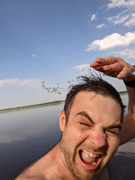 Glücklicher Mann planscht und schüttet sich frisches Wasser auf den Kopf, um sich bei heißem Wetter zu erfrischen — Stockfoto