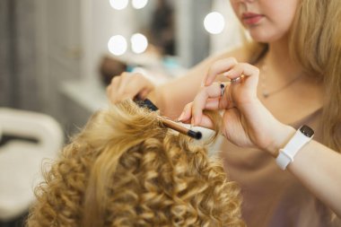Kuaför - saç stilisti, saç maşası, kadın müşteri saç tıraşı olur.