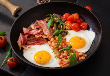 İngiliz kahvaltısı - kızarmış yumurta, fasulye, domates, mantar, pastırma ve tost.