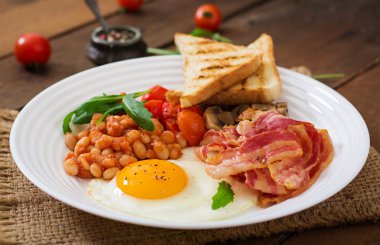 İngiliz kahvaltısı - kızarmış yumurta, fasulye, domates, mantar, pastırma ve tost.