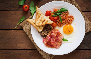 İngiliz kahvaltısı - kızarmış yumurta, fasulye, domates, mantar, pastırma ve tost.