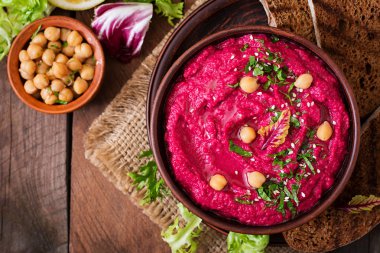 Kavrulmuş pancar Humus ile karanlık bir arka plan üzerinde seramik bir kasede tost