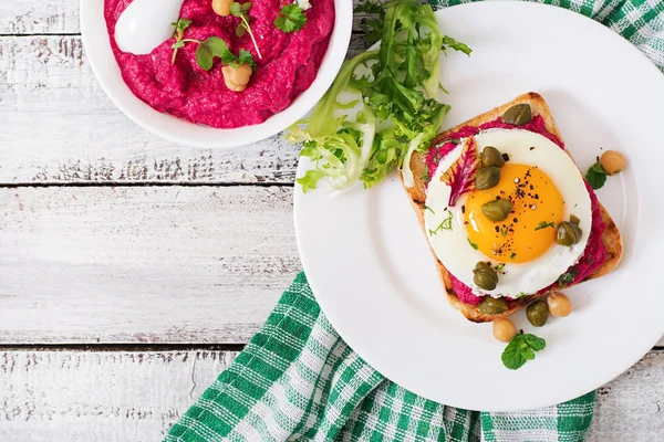 Диетические сэндвичи со свекловичным корнем хумуса, каперсами и яйцом — стоковое фото
