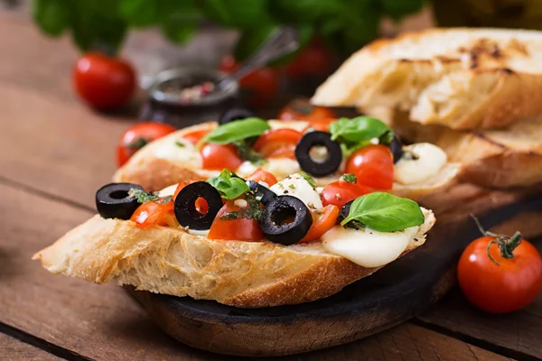 Bruschetta z pomidorami, mozzarellą, oliwki — Zdjęcie stockowe