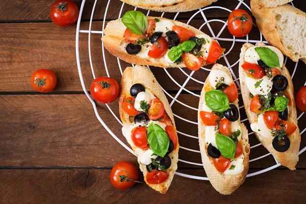 Bruschetta met tomaten, mozzarella, olijven — Stockfoto