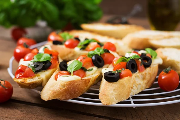 Bruschetta met tomaten, mozzarella, olijven — Stockfoto