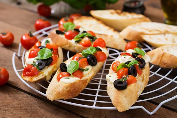 Bruschetta con pomodori, mozzarella, olive — Foto Stock