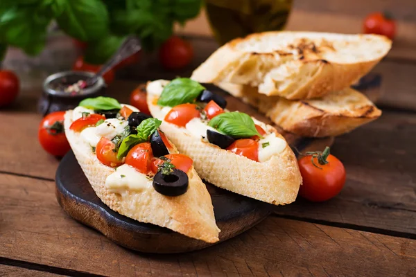 Bruschetta met tomaten, mozzarella, olijven — Stockfoto