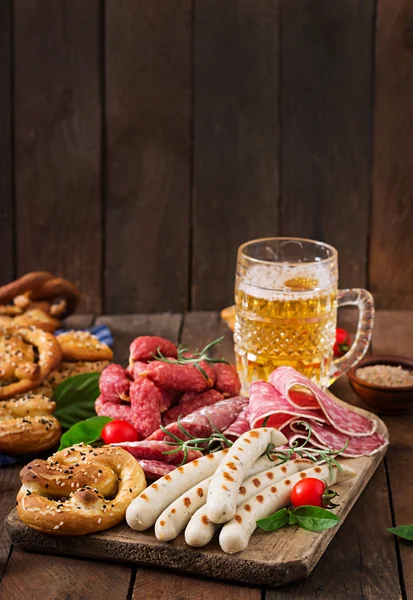 Glass of beer, pretzels and various sausages — Stock Photo, Image
