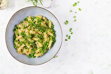 Vejetaryen salatası. Yeşil bezelye ve soğanlı Fusilli makarna. İtalyan yemeği. Üst Manzara. Düz yatıyordu.
