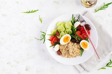 Kahvaltı yulaf lapası, Yunan salatası, salatalık, zeytin ve yumurta. Sağlıklı dengeli yiyecekler. Üst görünüm, düz görünüm, kopyalama alanı