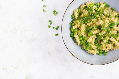 Vejetaryen salatası. Yeşil bezelye ve soğanlı Fusilli makarna. İtalyan yemeği. Üst Manzara. Düz yatıyordu.
