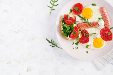 İngiliz kahvaltısı. Yağda yumurta, sosis, domates ve peynir. Amerikan yemeği. Üst görünüm, genel görünüm, kopyalama alanı