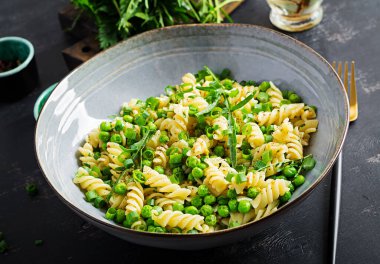 Vejetaryen salatası. Yeşil bezelye ve soğanlı Fusilli makarna. İtalyan yemeği..