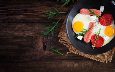 İngiliz kahvaltısı. Yağda yumurta, sosis, domates ve peynir. Amerikan yemeği. Üst görünüm, genel görünüm, kopyalama alanı