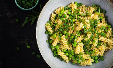 Vejetaryen salatası. Yeşil bezelye ve soğanlı Fusilli makarna. İtalyan yemeği. Üst Manzara. Düz yatıyordu.
