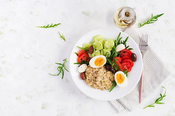 トマト キュウリ オリーブ 卵のギリシャサラダと朝食オートミール粥 健康的なバランスの取れた食品 トップビュー フラットレイアウト コピースペース — ストック写真