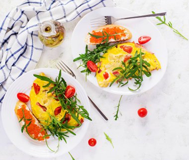 Domatesli omlet, peynir, jambon ve tabakta kırmızı cavier sandviçi. Frittata - İtalyan omleti. Üst görünüm, genel görünüm, kopyalama alanı