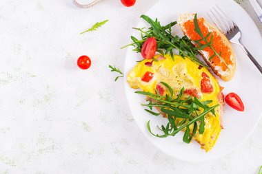 Domatesli omlet, peynir, jambon ve tabakta kırmızı cavier sandviçi. Frittata - İtalyan omleti. Üst görünüm, genel görünüm, kopyalama alanı