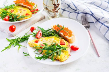 Domatesli omlet, peynir, jambon ve tabakta kırmızı cavier sandviçi. Frittata - İtalyan omleti.