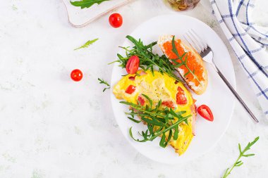 Domatesli omlet, peynir, jambon ve tabakta kırmızı cavier sandviçi. Frittata - İtalyan omleti. Üst görünüm, genel görünüm, kopyalama alanı