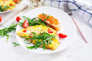 Domatesli omlet, peynir, jambon ve tabakta kırmızı cavier sandviçi. Frittata - İtalyan omleti.