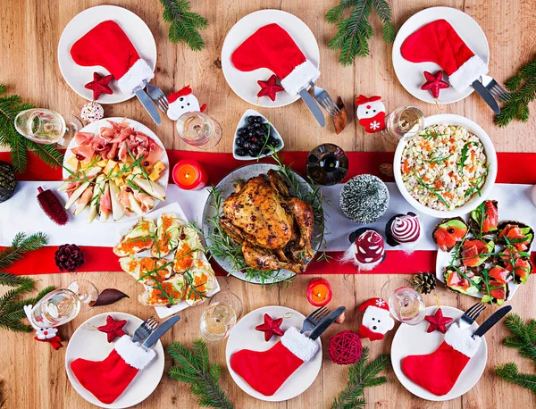 Baked turkey. Christmas dinner. The Christmas table is served with a turkey, decorated with bright tinsel and candles. Fried chicken, table.  Family dinner. Top view, flat lay, overhead, copy space