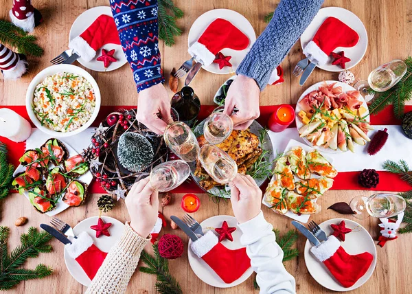 Baked turkey. Christmas dinner. The Christmas table is served with a turkey, decorated with bright tinsel and candles. Fried chicken, table.  Family dinner. Top view, hands in the frame