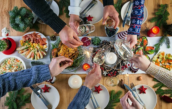 Baked turkey. Christmas dinner. The Christmas table is served with a turkey, decorated with bright tinsel and candles. Fried chicken, table.  Family dinner. Top view, hands in the frame