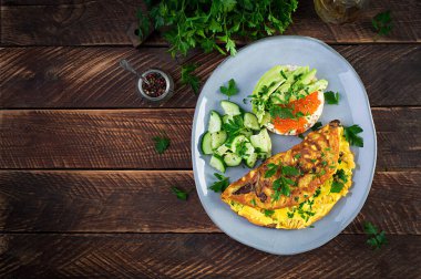 Orman mantarlı omlet, fusilli makarna ve kırmızı cavier sandviçi, tabakta avokado. Frittata - İtalyan omleti. Üst görünüm, genel görünüm, kopyalama alanı