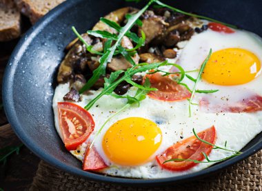 Lezzetli kahvaltı. Yağda yumurta, orman mantarı, domates ve roka. Öğle yemeği..