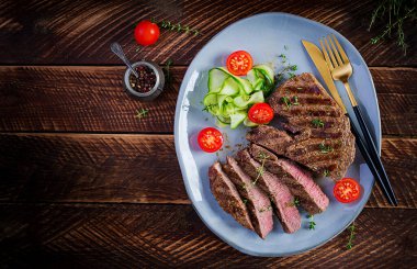 Izgara, sulu, orta pişmiş, baharatlı biftek ve taze salata. Üst görünüm, genel görünüm, düz görünüm