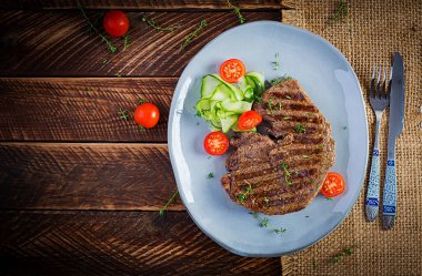 Izgara, sulu, orta pişmiş, baharatlı biftek ve taze salata. Üst görünüm, genel görünüm, düz görünüm
