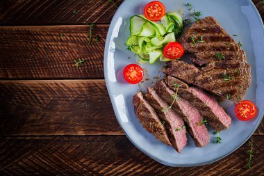 Izgara, sulu, orta pişmiş, baharatlı biftek ve taze salata. Üst görünüm, genel görünüm, düz görünüm