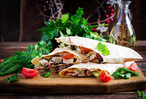 焼きトルティーヤは 木製のボード上の鶏や新鮮な野菜で包みます チキンブリトー メキシコ料理 健康食品の概念 メキシコ料理 — ストック写真