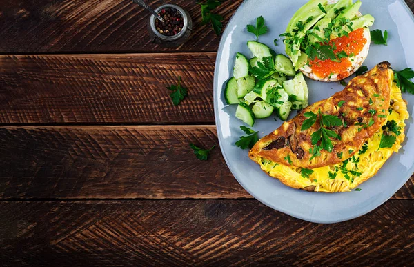 Omelette with forest mushroom, fusilli pasta and sandwich wich red caviar, avocado on plate. Frittata - italian omelet. Top view, overhead, copy space — Stock Image Omelette Forest Mushroom Fusilli Pasta Sandwich Wich Red Caviar Avocado Stock Image