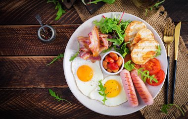 İngiliz kahvaltısı - kızarmış yumurta, fasulye, domates, sosis, pastırma ve tost. Üst görünüm, düz görünüm, genel görünüm