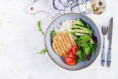 Tavuk şnitzel ya da pirzola, tavuk eti ızgara ve taze salatayla haşlanmış beyaz pirinç. Öğle yemeği için sağlıklı diyet menüsü. Üst görünüm, genel görünüm