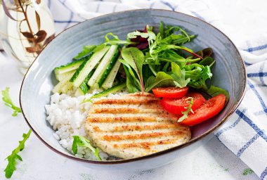 Tavuk şnitzel ya da pirzola, tavuk eti ızgara ve taze salatayla haşlanmış beyaz pirinç. Öğle yemeği için sağlıklı diyet menüsü.