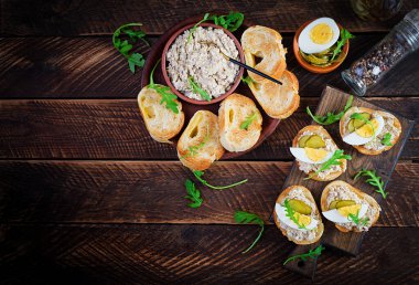 Ahşap kesme tahtasının üzerinde tuzlanmış morina balığı kremalı tost ekmeği. Kızarmış ekmeğin üzerine uskumru ezmesi. İskandinav mutfağı. Üst görünüm, genel görünüm