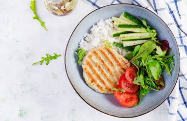 Tavuk şnitzel ya da pirzola, tavuk eti ızgara ve taze salatayla haşlanmış beyaz pirinç. Öğle yemeği için sağlıklı diyet menüsü. Üst görünüm, genel görünüm