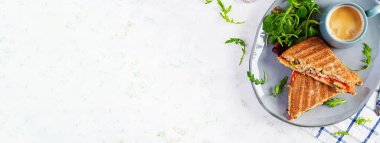 Biftek, domates, peynir, marul ve kahve ile ızgara sandviç sandviçi. Lezzetli kahvaltı ya da atıştırmalık. Üst görünüm, genel görünüm, afiş