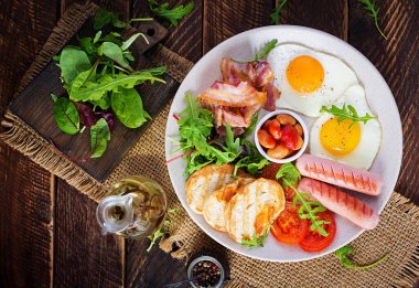 İngiliz kahvaltısı - kızarmış yumurta, fasulye, domates, sosis, pastırma ve tost. Üst görünüm, düz görünüm, genel görünüm