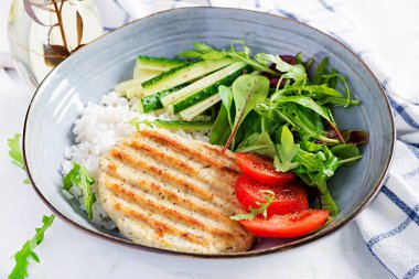 Tavuk şnitzel ya da pirzola, tavuk eti ızgara ve taze salatayla haşlanmış beyaz pirinç. Öğle yemeği için sağlıklı diyet menüsü.